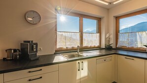 A modern kitchen with a sink, stove, and cabinets. - Cozy vacation apartment with unobstructed views of the surrounding mountains (Inzing)