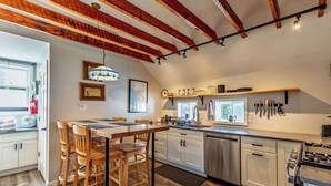 A modern kitchen with wooden chairs, a dining table, and a built-in oven. - Private Renovated Apt w/ Washer/Dryer near dwntwn! (Burlington)