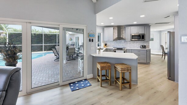 A modern kitchen with a large island, white cabinetry, and a built-in microwave. - Remodeled Waterfront Home w/ Heated Pool  in Punta Gorda (Punta Gorda)