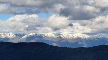 Eine gebirgige Landschaft mit schneebedeckten Gipfeln und blauem Himmel.