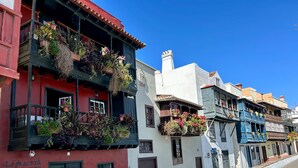 Una hilera de edificios coloridos con balcones decorados con plantas.