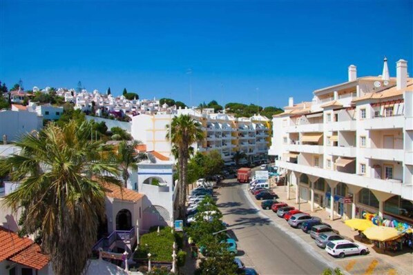 A coastal town with white buildings, a street with parked cars, and a clear blue sky. - Apartment 'Fernandes' with Mountain View, Wi-Fi and Air Conditioning (Carvoeiro)
