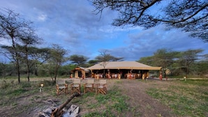 A safari lodge with an open dining area, outdoor seating, and a fire pit. - Africa Safari Serengeti Kusini  (Bariadi)