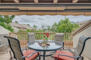 Relax in style on this inviting patio, surrounded by lush palm trees and comfortable seating for six.