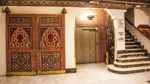 A grand entrance with ornate doors and a marble staircase leading to a higher floor. - HOTEL LA PERLE DU SUD (Ouarzazate)