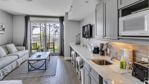 A modern kitchen with a large window, a built-in microwave, and a bar area.