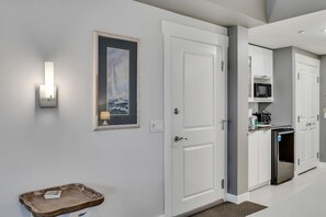 A modern kitchen with white cabinets, a microwave, and a built-in oven.