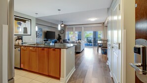 A modern kitchen with a central island, wooden cabinets, and a dining area with a table and chairs. - 3rd-Floor Bayfront Serenity: 2 Bedroom, 3 Baths, Sunset Views, Private Balcony at Sandestin Golf and Beach Resort! (Miramar Beach)