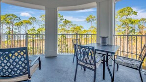 A covered outdoor area with a table and chairs, a bench, and a view of trees and sky. - 3rd-Floor Bayfront Serenity: 2 Bedroom, 3 Baths, Sunset Views, Private Balcony at Sandestin Golf and Beach Resort! (Miramar Beach)