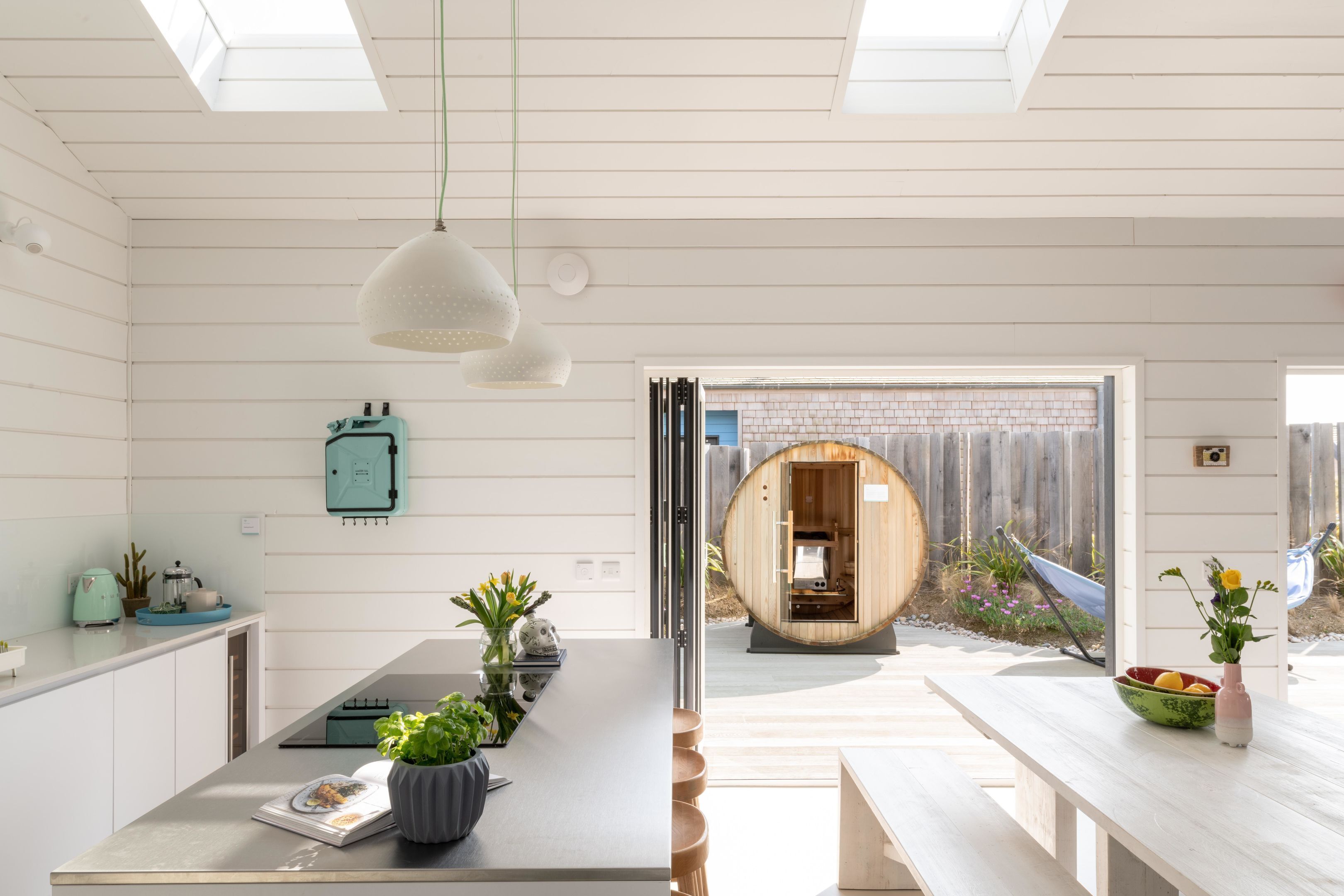 A modern kitchen with a central island, pendant lighting, and a view of the backyard.