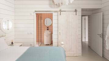 Un dormitorio con cama, mesita de noche, espejo, armario y un baño visible a través de una puerta abierta.
