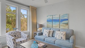 Ein Wohnzimmer mit einem blauen Sofa, einem gemusterten Sessel und einem Couchtisch mit Dekoration.