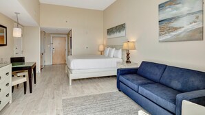 Une chambre à coucher avec un lit, un canapé bleu, un bureau et une chaise.