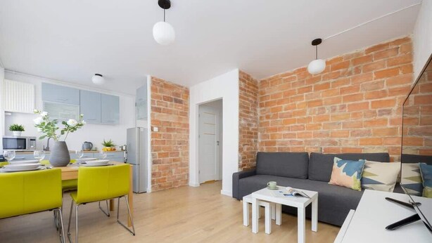 Un espacio habitable moderno con cocina, comedor y sala de estar con sofá y mesa de centro.