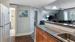 A modern kitchen with granite countertops, wooden cabinets, and a stainless steel sink.
