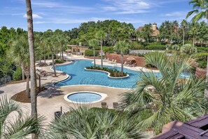 Un área de piscina en un complejo turístico, con varias piscinas, palmeras y sillones de descanso.
