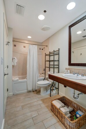 A bathroom with a bathtub, toilet, and sink.