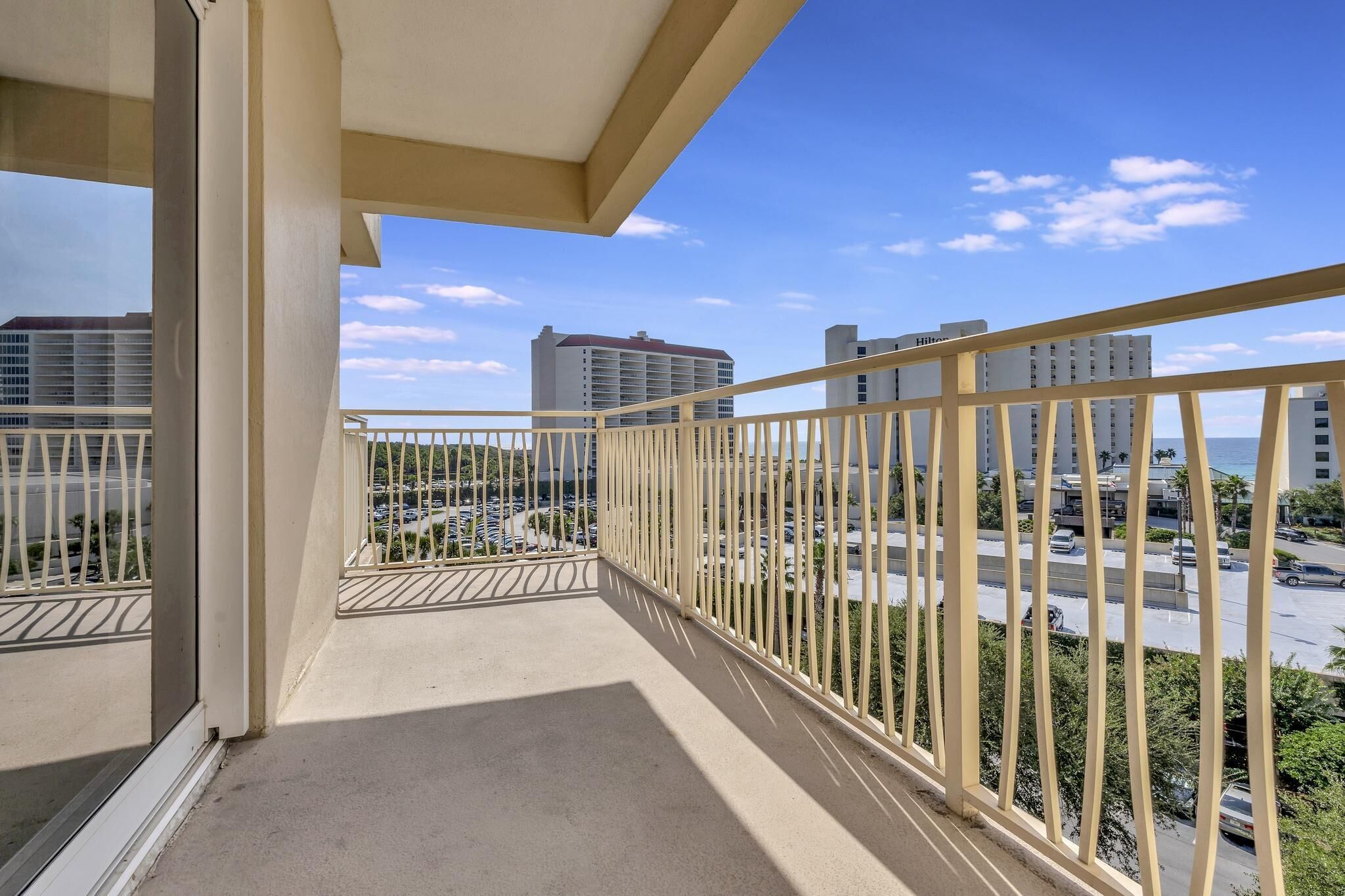 Ein Balkon mit Blick auf hohe Gebäude und einen Parkplatz.
