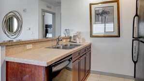 Una cocina moderna con lavavajillas incorporado, un lavamanos y un refrigerador.