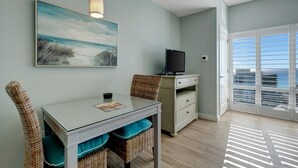 Una habitación con una mesa de comedor, sillas, un televisor y un ventanal con vistas.