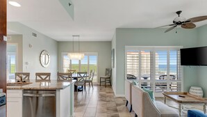 Una cocina amplia con comedor, una sala de estar con sofá y televisor, y un balcón con vistas.