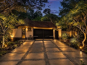 A house with a tiled roof, a paved driveway, and a garage.