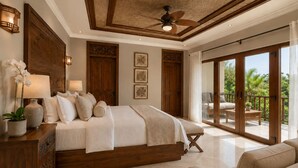 A spacious bedroom with a large bed, a ceiling fan, and a balcony with a view of greenery. - 5-Acre Private Jungle Estate | Ocean Views, Huge Pool, Chef & Transportation (Playa Tamarindo)