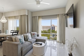 A modern living room with a sofa, coffee table, and dining area.