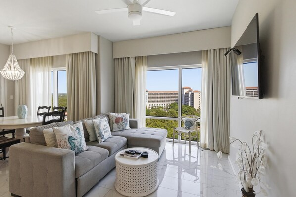 A modern living room with a sofa, coffee table, and dining area.