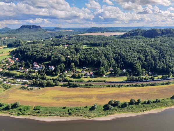 An aerial view of a town with a river, surrounded by forests and fields.