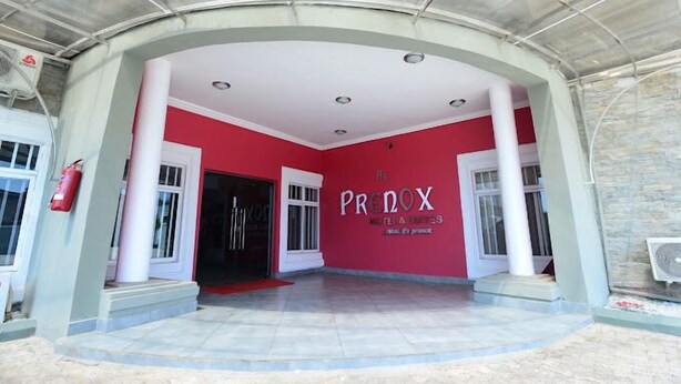 A hotel entrance with a red wall and the name 'PRENOX' prominently displayed. - Prenox Hotel and Suites  (Benin City)