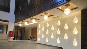 A hotel lobby with a modern design, featuring a staircase, a reception desk, and decorative lighting. - AJ's Arcade (Pathankot)