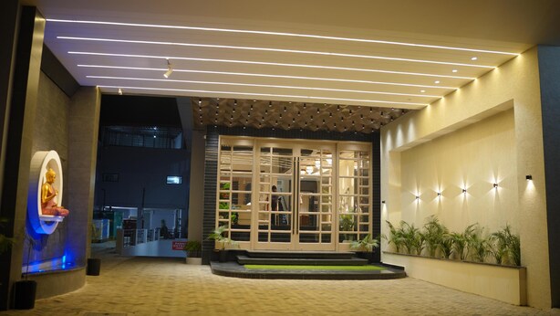 A modern building entrance with a glass door, illuminated ceiling, and potted plants. - AJ's Arcade (Pathankot)