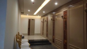 A hallway with a modern design, featuring a long reception desk, a staircase, and decorative wall panels. - AJ's Arcade (Pathankot)