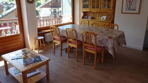 A dining area with a wooden table and chairs, a wooden cabinet, and a view of a balcony with a railing. - Resort center, 3rd floor, balcony, parking, 53m², Valloire (Valloire)