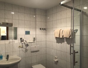 A modern bathroom with a sink, toilet, and shower. - Gasthaus Klosterhof (Wertheim)