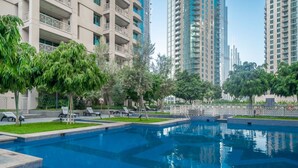 A swimming pool surrounded by trees and modern buildings. - Bellavista-29BLVD Fabulous Fountain View (Dubai)