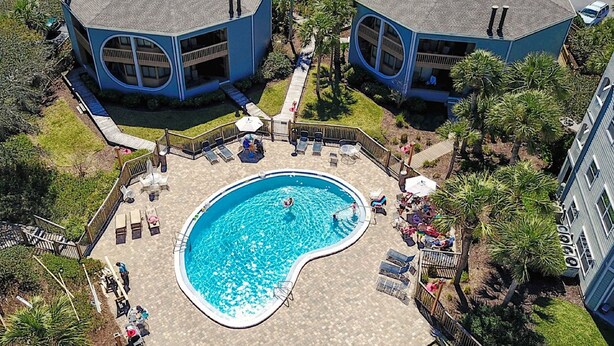 An aerial view of a residential area with two blue houses, a swimming pool, and surrounding greenery. - Ocean Gate I306 in St Augustine (St. Augustine)