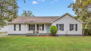 A single-story house with a front porch, a small front yard, and a well-maintained lawn. - Clean 3BR · Quiet Block · Backyard with Hoop (Spring Hill)