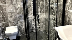 A modern bathroom with a glass-enclosed shower, a white toilet, and a sink. - The Port Palace Otel (Istanbul)