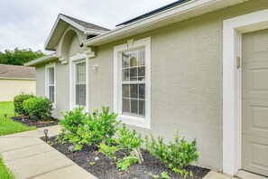 A residential house with a garage, a front yard with shrubs, and a sidewalk. - Near Dtwn: Family-friendly Palm Coast Getaway! (Palm Coast)