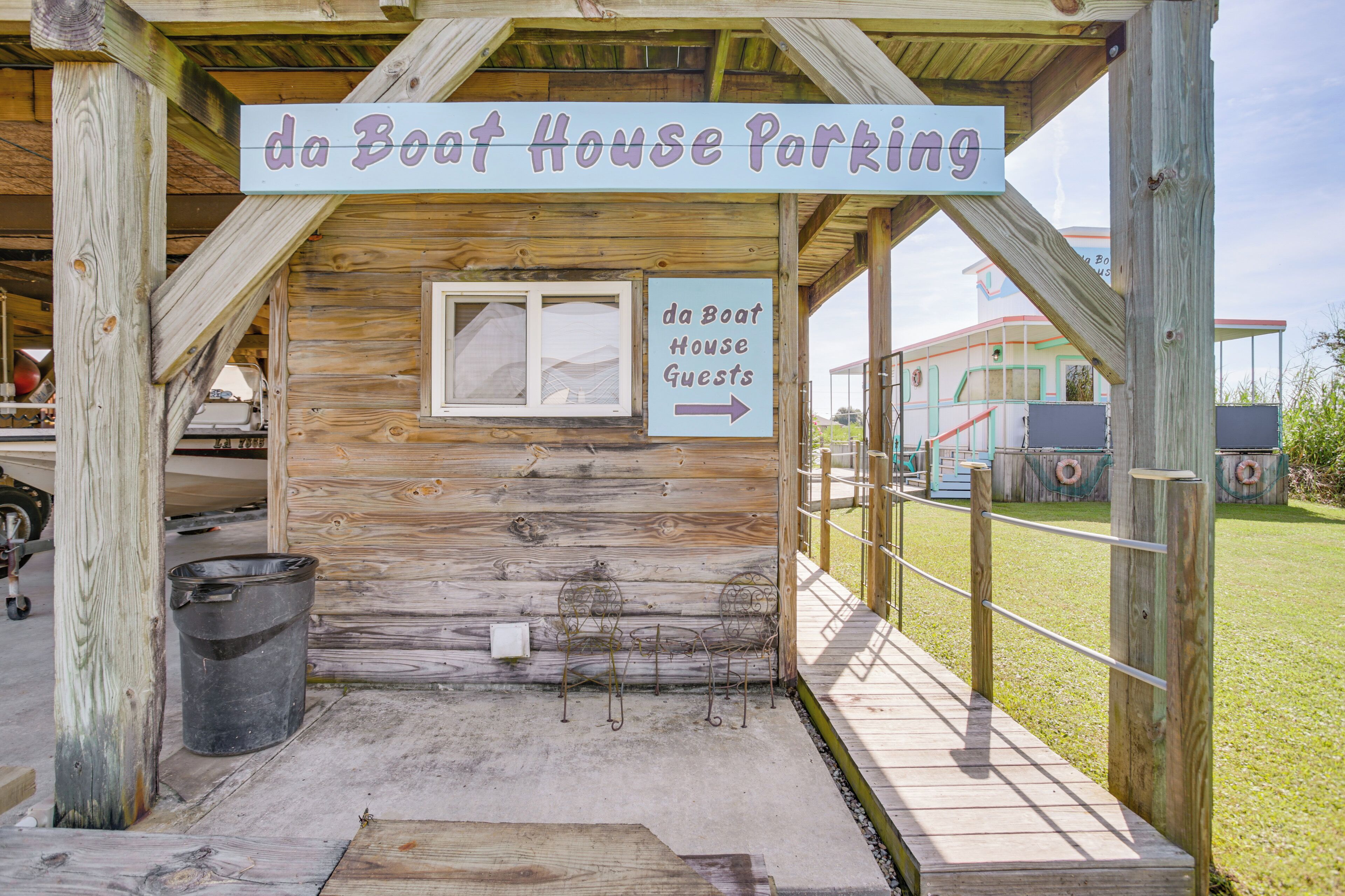 A wooden building with a sign indicating 'da Boat House Parking' and an arrow pointing to the right.