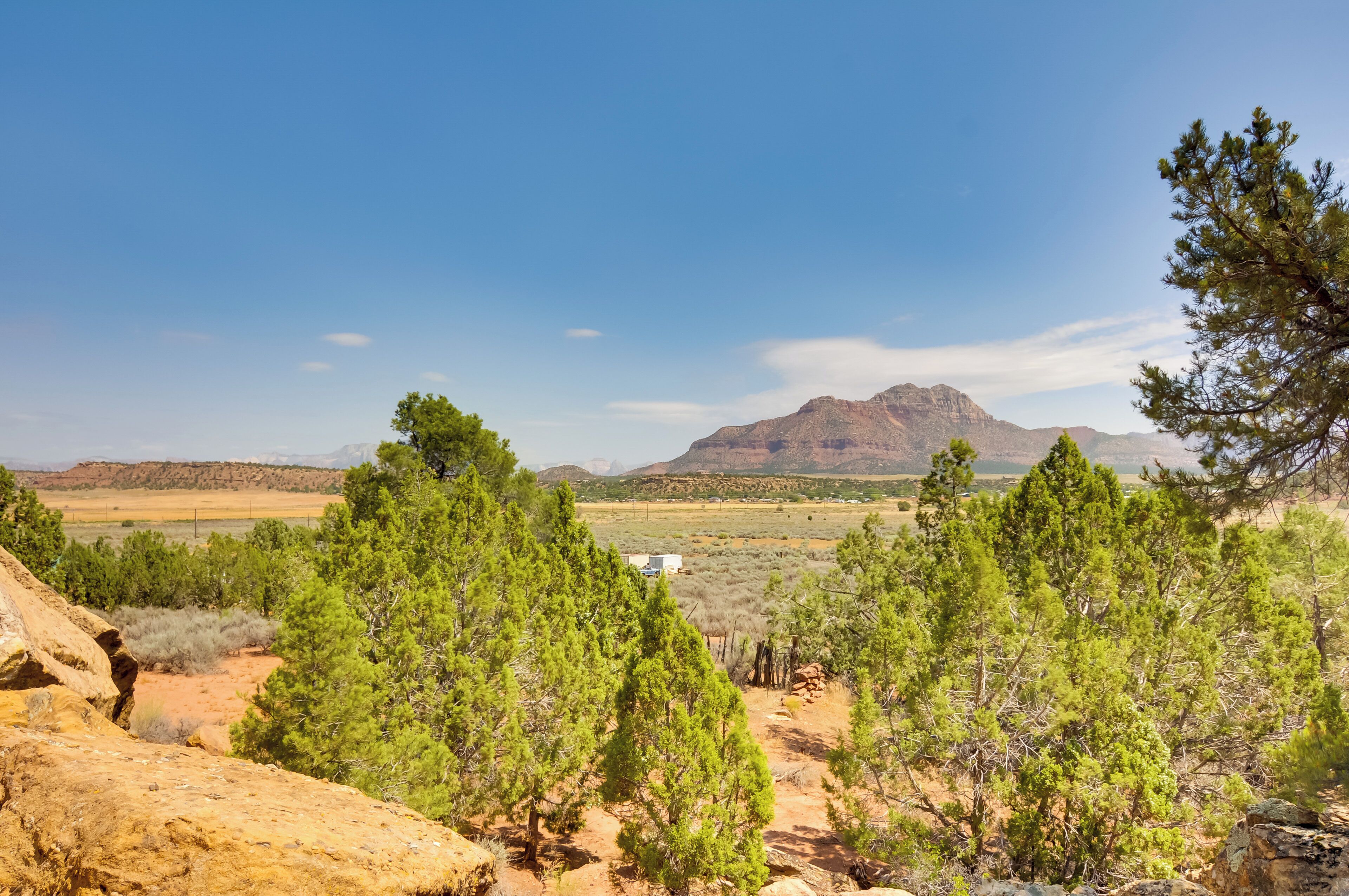 A mountainous landscape with sparse vegetation and a clear sky.