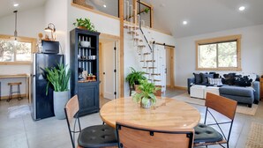 Un espace de vie moderne comprenant une cuisine, un coin repas et une chambre en mezzanine.