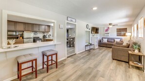 A modern kitchen with a bar area, a living room with a sofa and a coffee table, and a dining area with a table and chairs. - Somerville Lake House - Walk to Water! (Somerville)