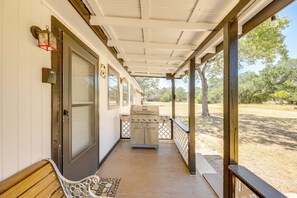 A covered porch with a grill, a bench, and a door. - Somerville Lake House - Walk to Water! (Somerville)