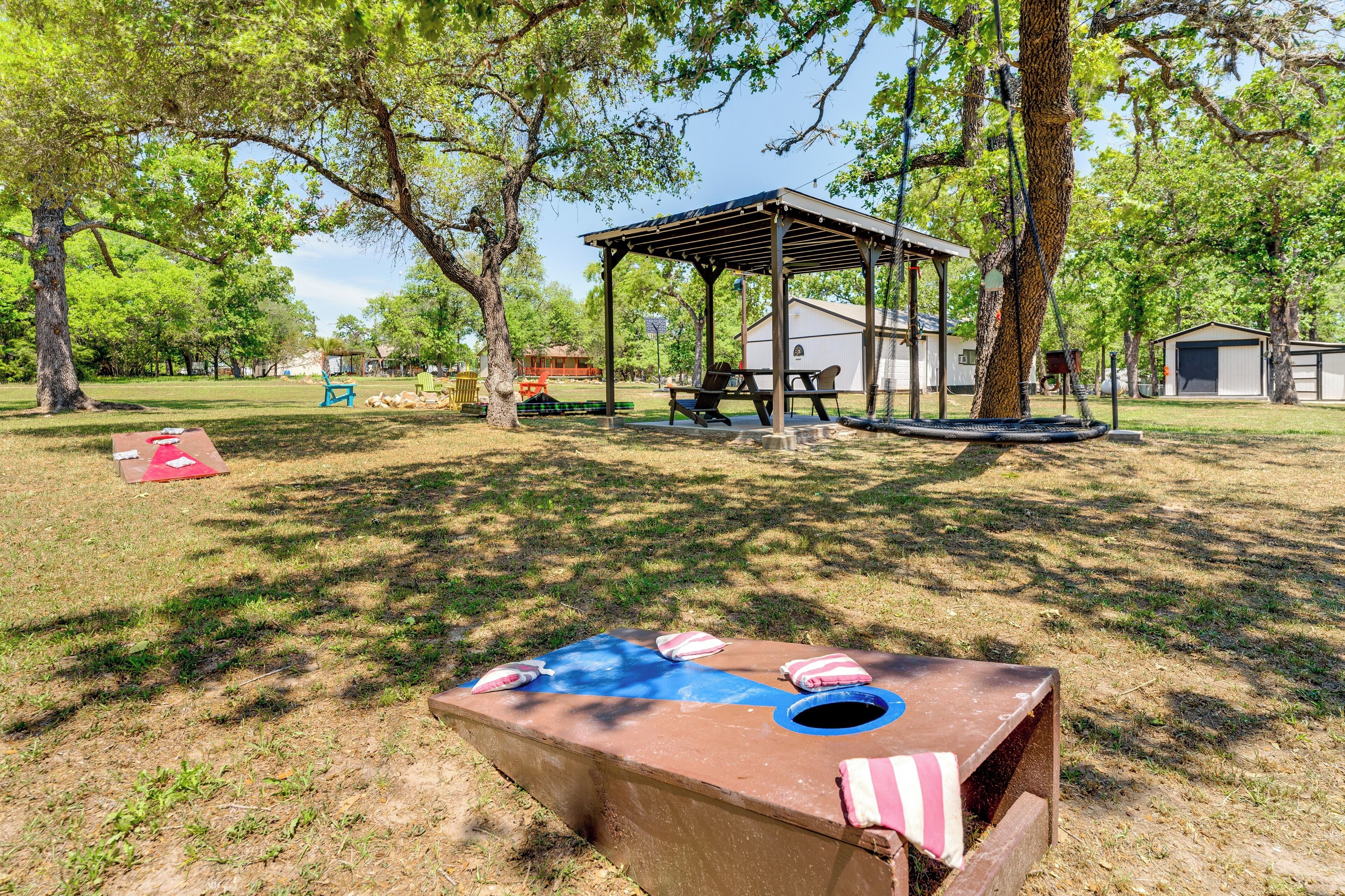 Un'area picnic con tavolo, panche e un padiglione coperto in un parco.