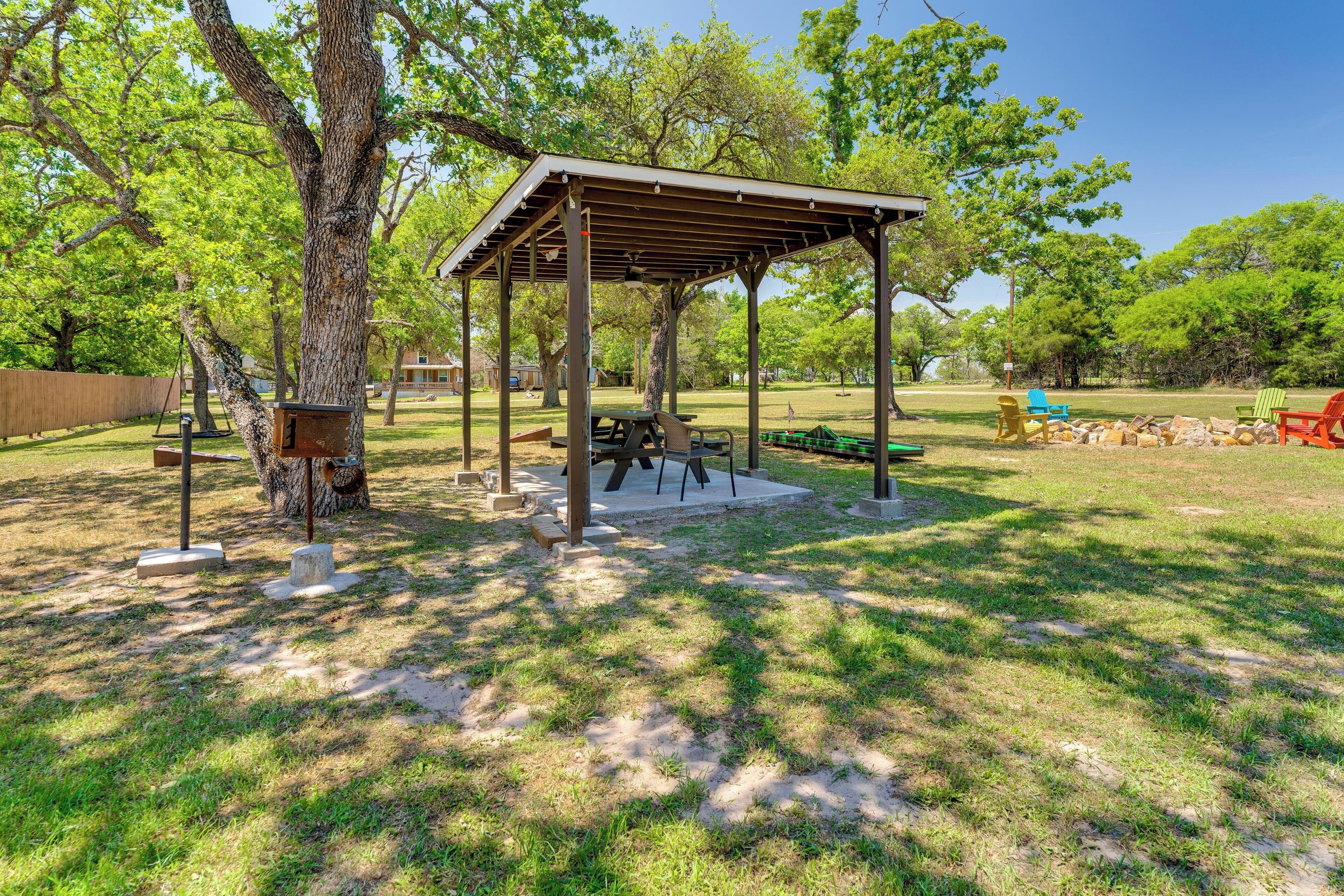A park with a wooden gazebo, picnic tables, and a playground area.