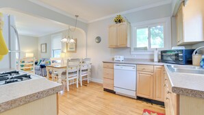 A modern kitchen with wooden cabinets, a built-in dishwasher, and a microwave. - Walk to Lake Michigan: Pet-friendly Charlevoix Gem (Charlevoix)