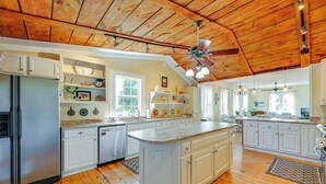 A spacious kitchen with wooden floors, white cabinetry, and a central island. - Home w/ Fire Pit < 1 Mi to Willis Wharf Boat Ramp! (Exmore)
